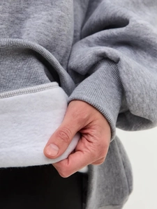 Macro view of grey sweatshirt showing thick white fleece lining and soft fabric texture