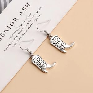 Vue détaillée de boucles d'oreilles bottes de cowboy argentées avec gravures vintage ciselées
