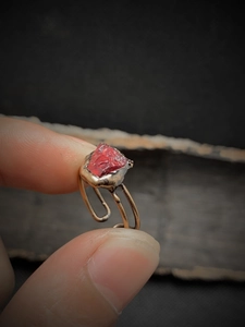Macro detail of natural irregular red stone set in vintage adjustable golden ring