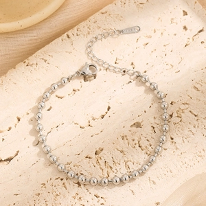 Polished stainless steel beaded chain bracelet with lobster clasp on beige stone