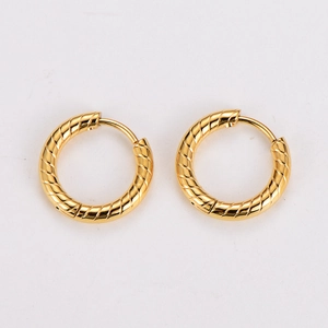 Detailed view of gold hoop earrings with textured diagonal twist and metallic luster