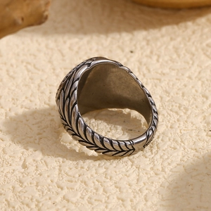 Retro vintage silver steel ring with wheat pattern engraving on a textured background