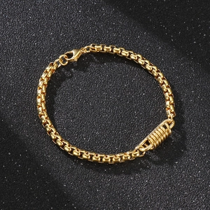 Vue détaillée du bracelet à chaîne vénitienne dorée avec breloque cylindrique en spirale