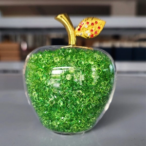 Close-up of a green crystal apple ornament with a golden stem and jeweled leaf