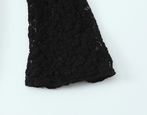 Vue macro détaillée de la texture de dentelle noire sur les manches de la robe