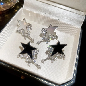 Detail of silver star earrings with pavé stones and white mother of pearl inserts