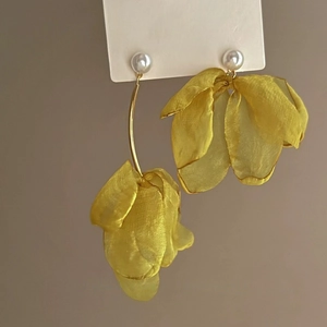 Detail view of yellow organza flower earrings with pearl accents and asymmetric tassels