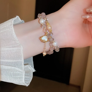 Détail d'un bracelet double rang avec perles d'eau douce et breloques étoilées