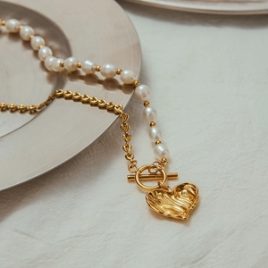 Detail of freshwater pearl necklace with gold heart pendant and OT toggle clasp
