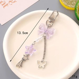 Détail du pendentif papillon en résine mauve de 13,5 cm avec breloques en étoile