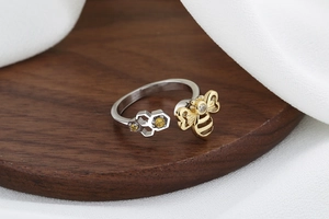Detailed view of bicolor open ring featuring a golden bee and silver honeycomb with gems