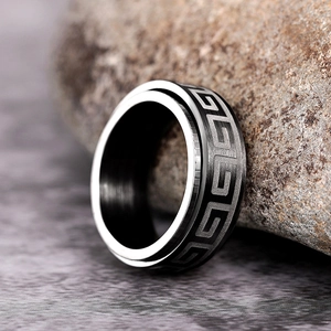 Macro shot of spinner ring with black matte Greek key pattern on rough stone