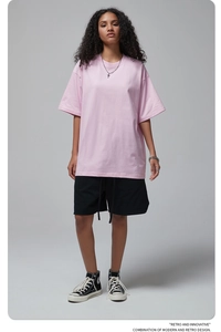 Full body shot of a model wearing a pink oversize cotton t-shirt with black shorts