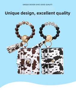 Detail of cow print card holder with silicone bead wristlet and decorative tassel