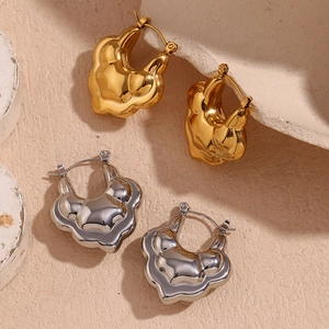 Close-up of gold and silver irregular double-layer hollow lotus hoop earrings