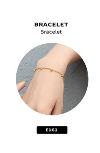Macro shot of minimalist gold bracelet featuring five delicate small metal beads on a fine chain