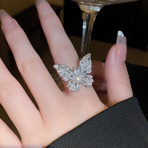 Dettaglio di un anello a farfalla scintillante con zirconi micro-pave su fascia aperta
