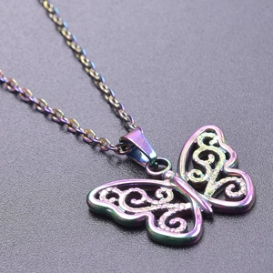 Macro detail of rainbow plated butterfly pendant with intricate scrollwork cutouts