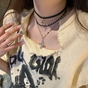 Detailed view of triple-layered cross necklace with leather cord and silver beads