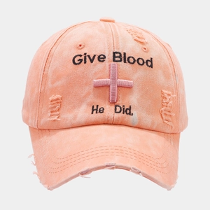 Macro shot of distressed peach cotton baseball cap with Give Blood embroidery