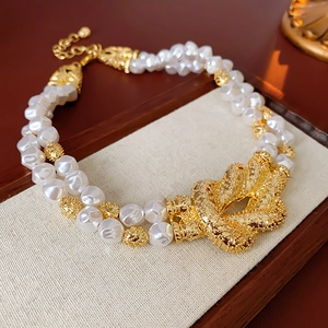 Detailed macro view of French double-layer baroque pearl necklace with golden knot texture