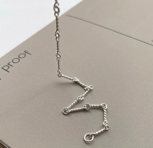 Macro detail of S925 sterling silver twisted rope chain bracelet with circular ring clasp