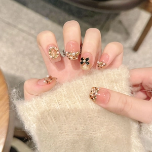 Handmade pink press-on nails with luxury bow, pearls and tweed texture patterns
