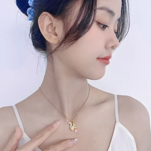 Close-up of a delicate golden squirrel pendant with sparkling zircons on a model's neck