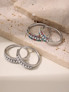 Detailed close-up of adjustable stainless steel rings with pearl and colored zircons