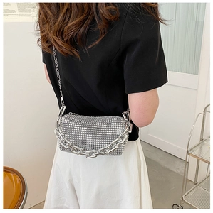 Detail view of silver rhinestone mini bag with elegant metal chain on female model