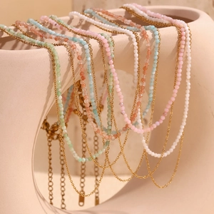 Detail of 18K gold plated layered necklace with colorful Amazonite beads on a vase