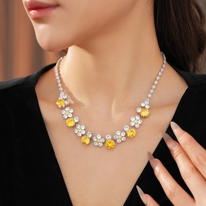 Close-up of a floral zircon necklace with yellow gems on a model with V-neck