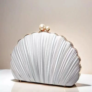 Dettaglio di pochette da sera a conchiglia argento con pieghe, perle e cornice dorata