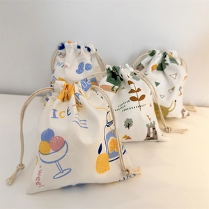 Detail of four cotton drawstring pouches with cute cartoon ice cream and lemon prints