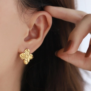 Irregular liquid metal flower earrings in 18K gold plated stainless steel on model