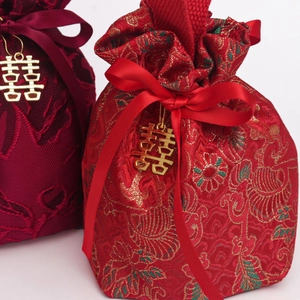Close-up of Chinese wedding candy bags with red brocade fabric and gold Xi charms
