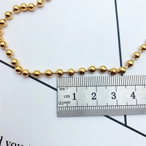 Macro shot of a 2.5mm gold bead ball chain showing polished texture and measurement scale
