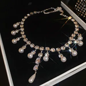 Elegant water drop zircon and round pearl necklace displayed on black velvet