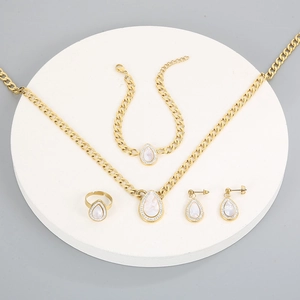 Detailed view of a gold jewelry set with teardrop shell pendants and sparkling crystals