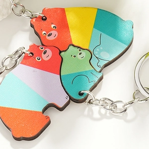 Cute family of three cartoon wooden bear puzzle keychains with colorful geometric patterns