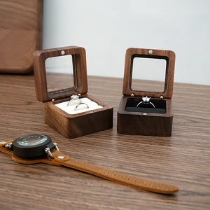 Detail view of walnut wood ring boxes with glass windows and black or white lining