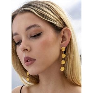 Model wearing 18k gold shell drop earrings with tiered conch design for beach style