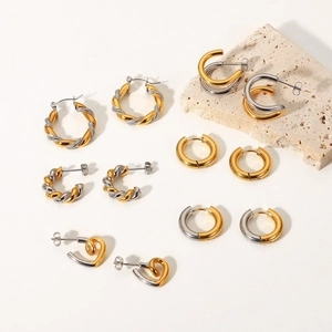 Macro shot of 18k gold plated stainless steel hoops and twist rings on stone