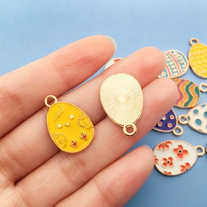 Macro shot of colorful enamel Easter egg charms with gold plating for DIY jewelry making