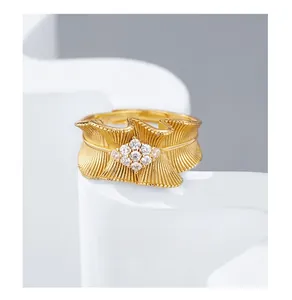 Detailed view of 925 silver gold-plated ring with wavy satin texture and zircon cluster