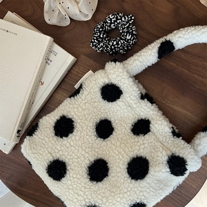 Gros plan du sac à main pelucheux à pois sur un bureau en bois avec décorations