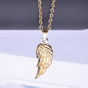 Macro shot of 18k gold plated stainless steel wing pendant with polished mirror finish