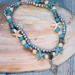 Detail of beach style beaded anklet with blue starfish and silver conch shell charm