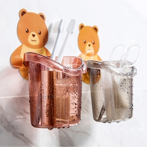 Wall-mounted bear toothbrush holder with amber and grey drainage cups in the bathroom