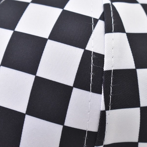 Primer plano de gorra de cuadros con doble costura blanca sobre tejido de sarga